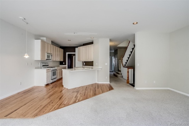 kitchen with light carpet, hanging light fixtures, white range with gas stovetop, sink, and white cabinetry