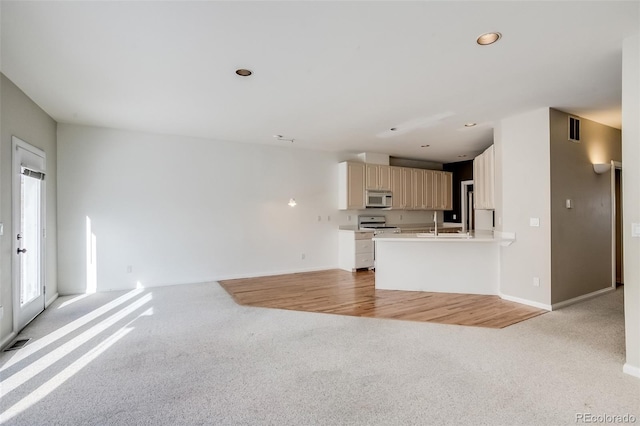 unfurnished living room featuring light colored carpet