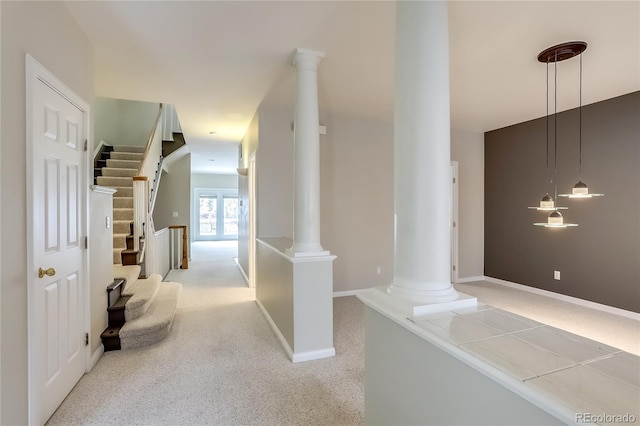 corridor with decorative columns and light carpet