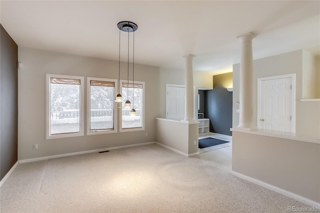 unfurnished room with light carpet and decorative columns