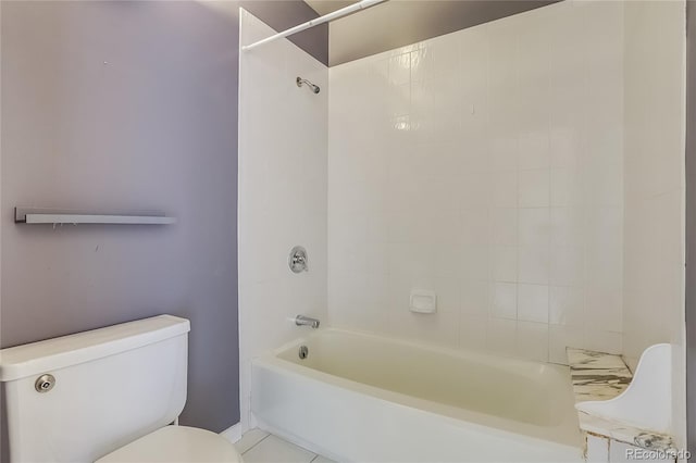 bathroom with tiled shower / bath combo, toilet, and tile patterned flooring