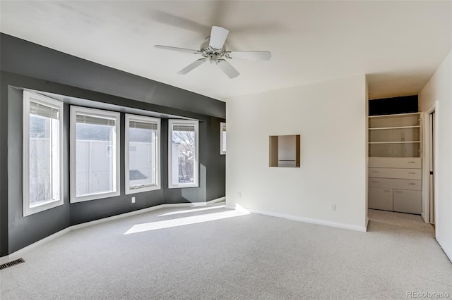 unfurnished room with light colored carpet and ceiling fan