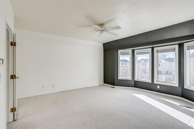 carpeted spare room with ceiling fan