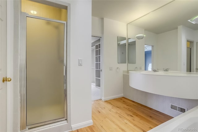 bathroom with hardwood / wood-style flooring and a shower with door