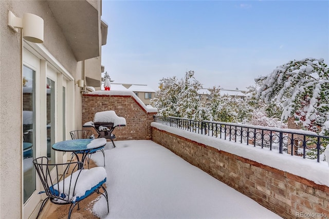 view of snow covered back of property