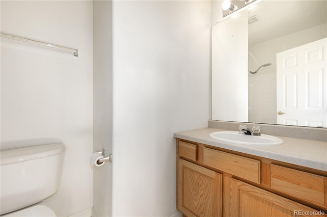 bathroom featuring a shower, vanity, and toilet