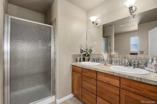 bathroom with tile patterned floors, a shower with door, and vanity