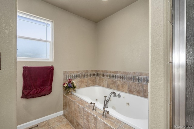 bathroom with tiled bath and tile patterned flooring