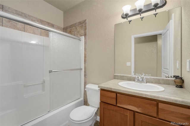 full bathroom featuring combined bath / shower with glass door, vanity, and toilet