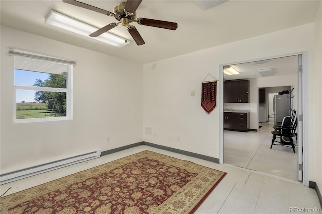 unfurnished room with ceiling fan, a baseboard heating unit, and light tile patterned floors