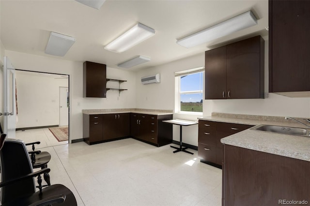 kitchen featuring sink, light tile patterned floors, a wall mounted air conditioner, and dark brown cabinetry