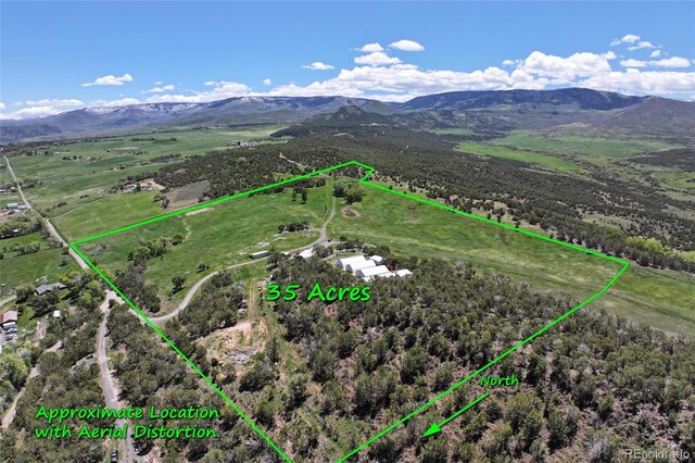 57191 Me Rd, Collbran, CO 81624 - aerial view of sparsely populated area with a mountainous background and property boundaries highlighted