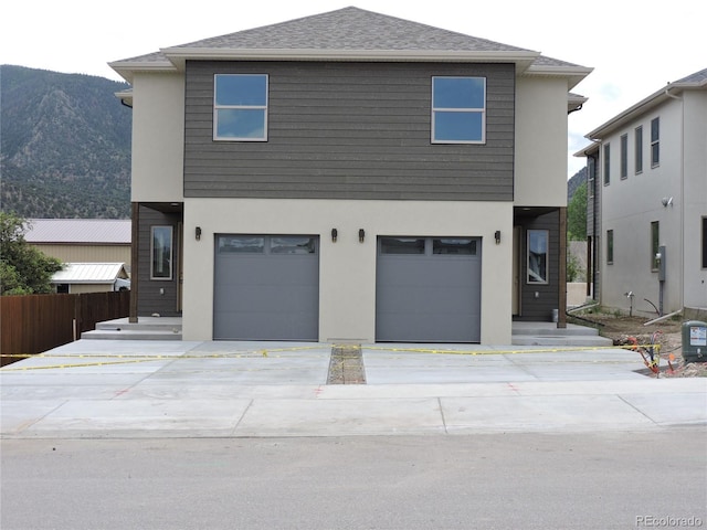 401 Alabama St Unit B, Poncha Springs, CO 81242 - view of front of property featuring stucco siding, an attached garage, driveway, and a mountain view