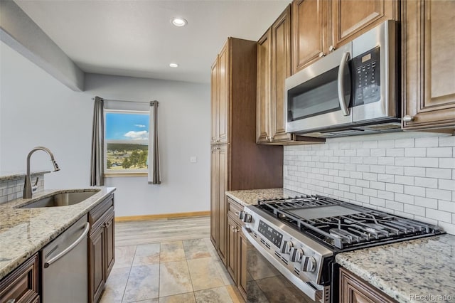 85 Estes Cir, Florissant, CO 80816 - kitchen with stainless steel appliances, a sink, recessed lighting, backsplash, and light stone counters