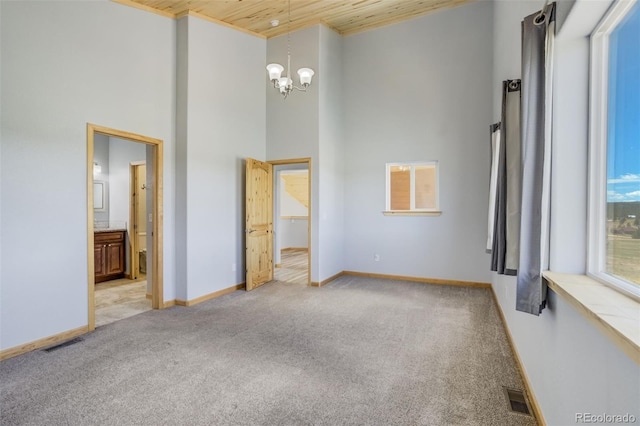 85 Estes Cir, Florissant, CO 80816 - spare room with wooden ceiling, a chandelier, light carpet, a towering ceiling, and baseboards