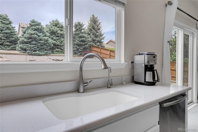 10540 Tracewood Cir, Highlands Ranch, CO 80130 - kitchen view of white cabinetry, stainless steel dishwasher, and light countertops