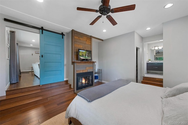 6283 S Prescott St, Littleton, CO 80120 - bedroom with wood finished floors, recessed lighting, a large fireplace, a barn door, and baseboards