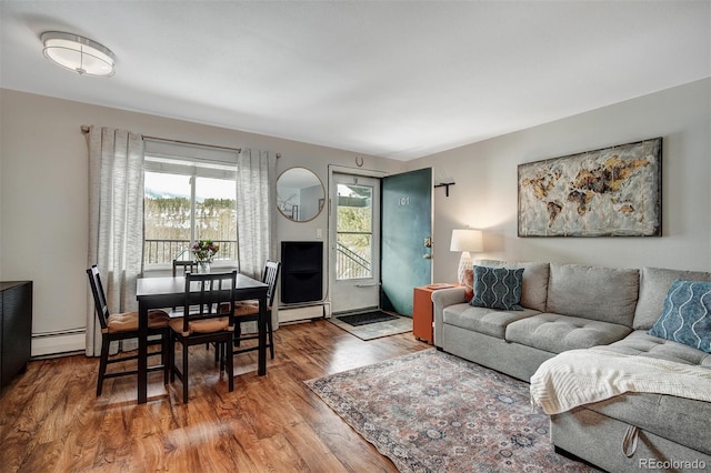 living room featuring a baseboard heating unit and wood finished floors