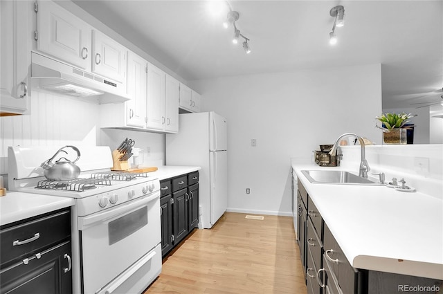 kitchen featuring sink, white appliances, white cabinetry, track lighting, and light hardwood / wood-style floors