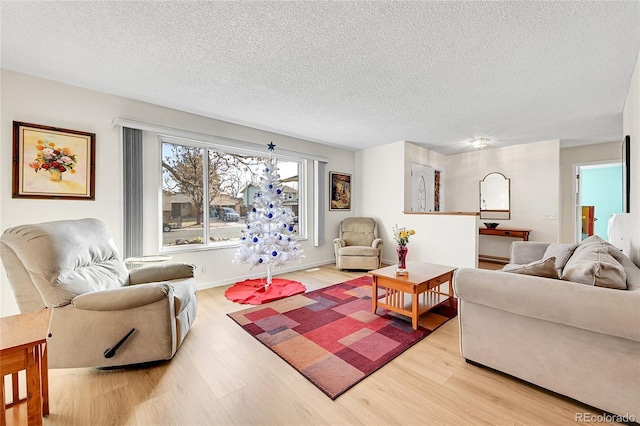 living room with light hardwood / wood-style floors and a textured ceiling