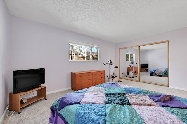 carpeted bedroom with a textured ceiling and a closet