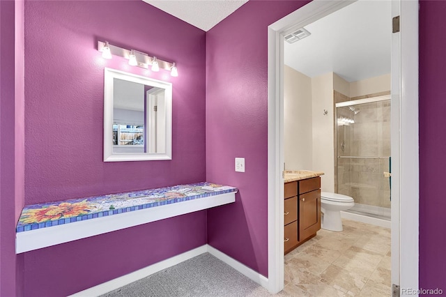 bathroom with vanity, toilet, and a shower with door