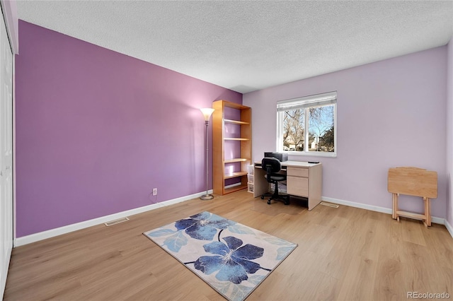 office with a textured ceiling and light hardwood / wood-style floors