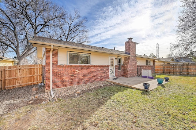 rear view of property featuring a yard and a patio