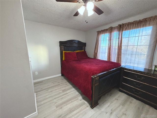 bedroom with ceiling fan, a textured ceiling, and light wood-type flooring