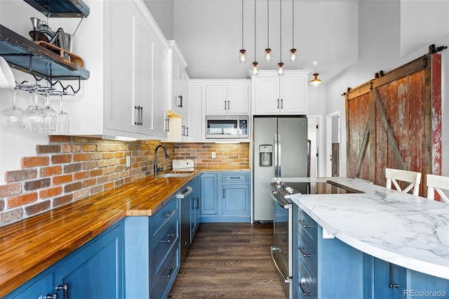 100 County Road 8344 Unit 3, Fraser, CO 80442 - kitchen with blue cabinetry, stainless steel appliances, wood counters, and a barn door