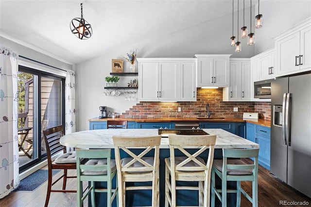 100 County Road 8344 Unit 3, Fraser, CO 80442 - kitchen with stainless steel appliances, butcher block countertops, vaulted ceiling, backsplash, and open shelves