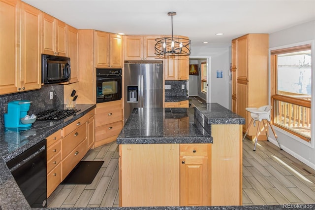 kitchen featuring black appliances, light brown cabinets, decorative light fixtures, and a center island