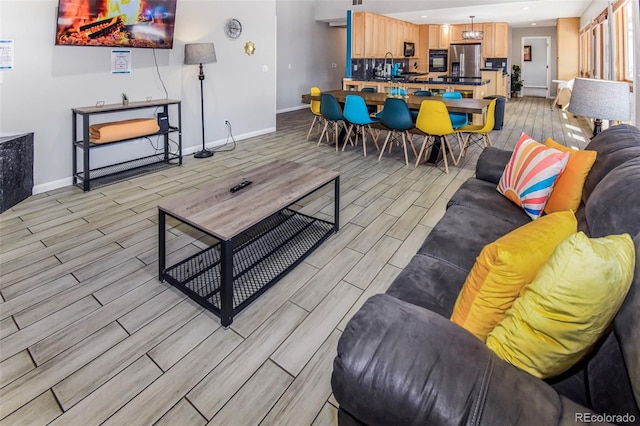 living room with light hardwood / wood-style flooring and sink