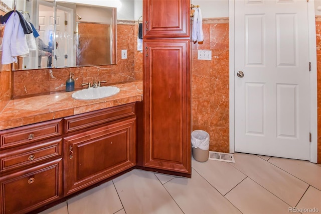 bathroom with vanity, tile walls, backsplash, and tile patterned floors