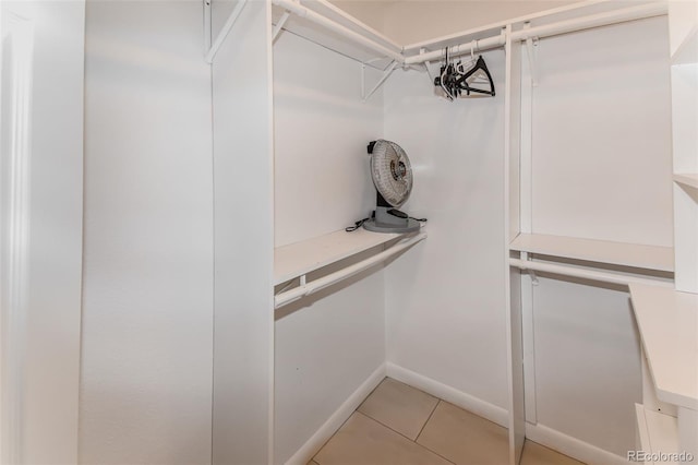 walk in closet with light tile patterned floors