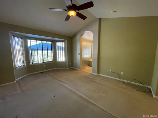 carpeted spare room featuring ceiling fan, a water view, and lofted ceiling