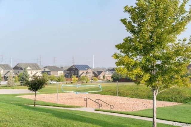 surrounding community with volleyball court and a lawn