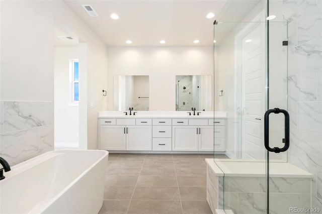 bathroom featuring a shower stall, double vanity, visible vents, a sink, and a freestanding tub