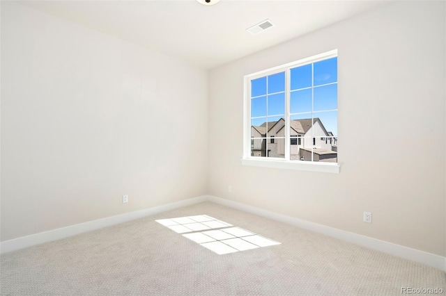 spare room with carpet, visible vents, and baseboards