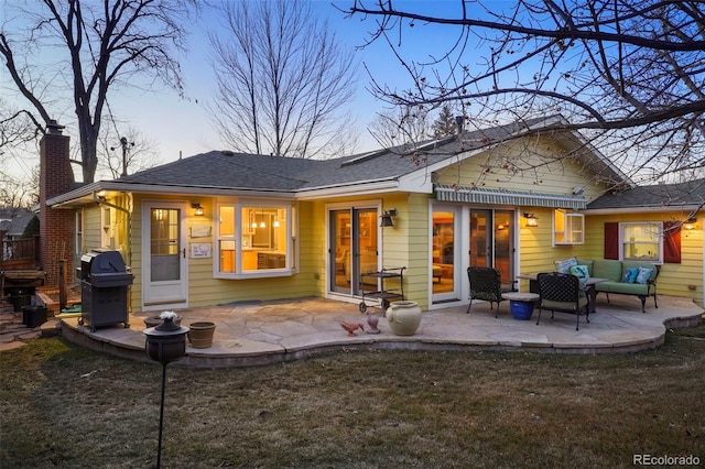 rear view of property featuring an outdoor hangout area, a patio, a lawn, and a chimney