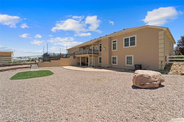 38087 E 147th Pl, Keenesburg, CO 80643 - back of property with a balcony, stucco siding, and a patio area