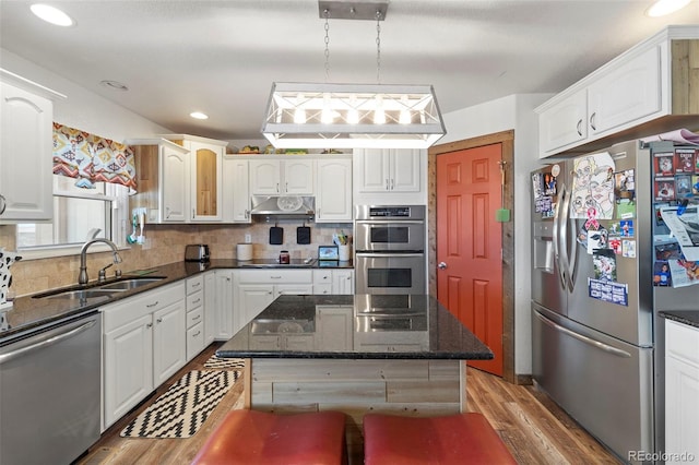 38087 E 147th Pl, Keenesburg, CO 80643 - kitchen featuring stainless steel appliances, light wood-style flooring, under cabinet range hood, white cabinets, and recessed lighting