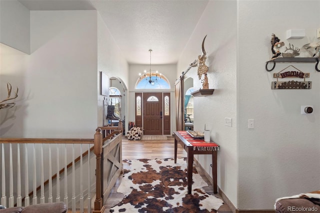 38087 E 147th Pl, Keenesburg, CO 80643 - entrance foyer featuring a chandelier, wood finished floors, and arched walkways