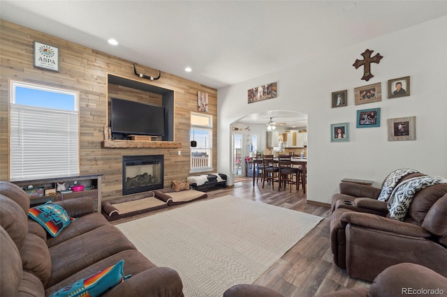 38087 E 147th Pl, Keenesburg, CO 80643 - living room with arched walkways, recessed lighting, a fireplace, wood finished floors, and wooden walls