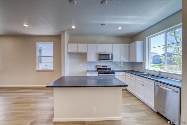 23951 E 40th Ave, Aurora, CO 80019 - kitchen with stainless steel appliances, a sink, white cabinets, light wood-style floors, and recessed lighting
