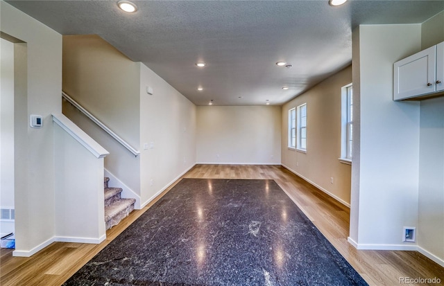 23951 E 40th Ave, Aurora, CO 80019 - unfurnished living room with recessed lighting, baseboards, stairs, and light wood-style flooring