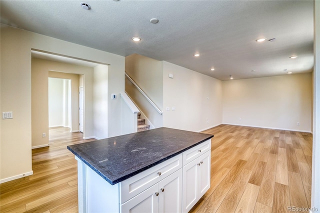 23951 E 40th Ave, Aurora, CO 80019 - kitchen featuring light wood-style flooring, white cabinets, recessed lighting, a kitchen island, and baseboards