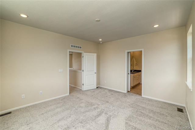 23951 E 40th Ave, Aurora, CO 80019 - unfurnished bedroom with light colored carpet, baseboards, recessed lighting, and connected bathroom