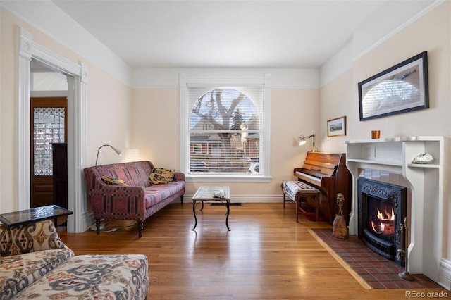 sitting room with a fireplace and wood finished floors