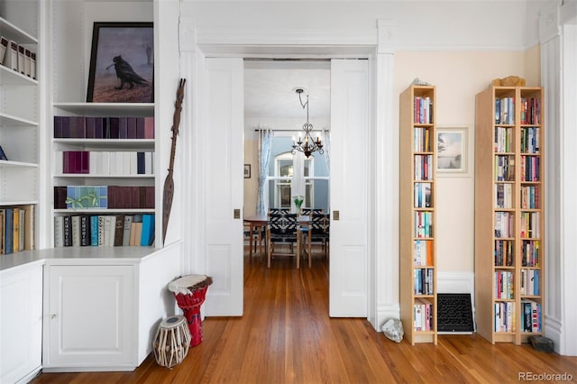 hall with a chandelier and wood finished floors